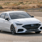 Side view of a sleek silver Hyundai Sonata parked under daylight. Modern midsize sedan showcasing bold design and aerodynamic curves.