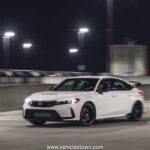 Front view of the bold and sporty red Honda Civic Type R showcasing its aggressive grille and large rear wing.