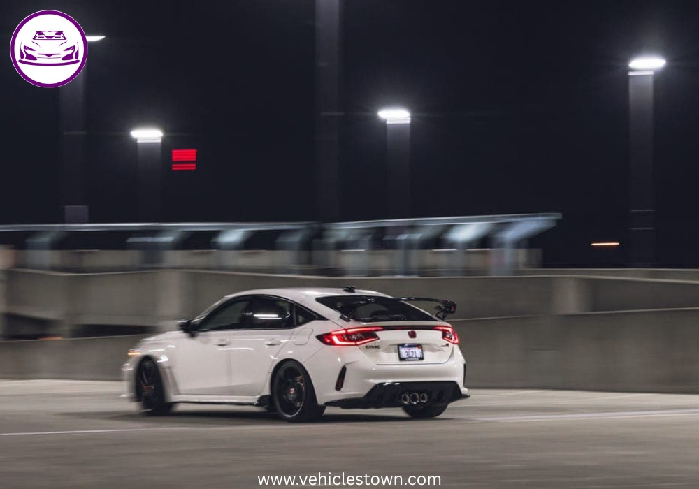 Front view of the bold and sporty red Honda Civic Type R showcasing its aggressive grille and large rear wing.