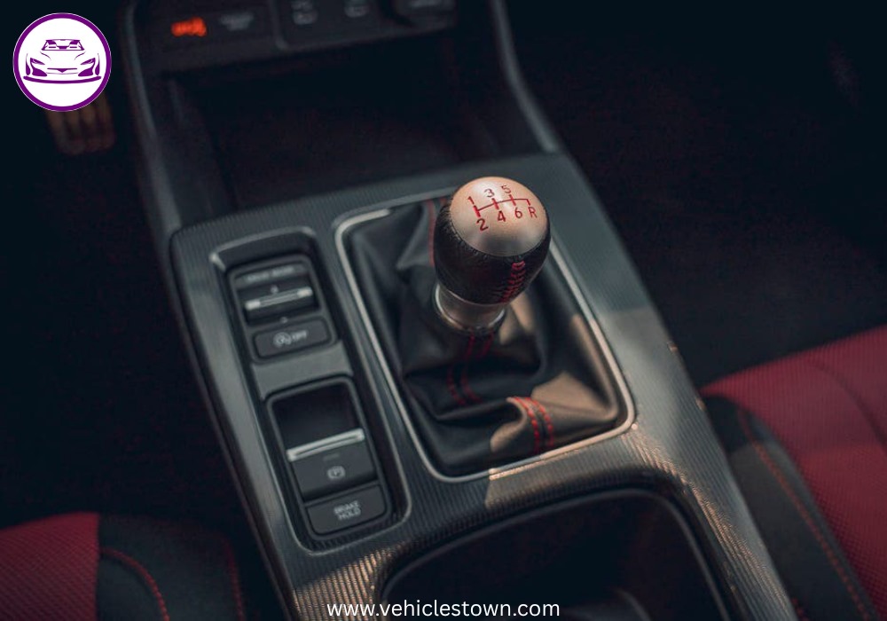 Honda Civic Si sporty red sedan parked, showcasing aggressive front grille and alloy wheels.