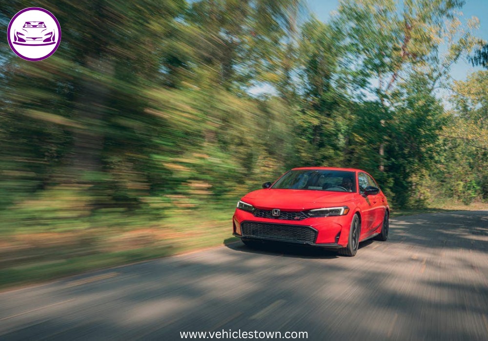 Honda Civic Si sporty red sedan parked, showcasing aggressive front grille and alloy wheels.