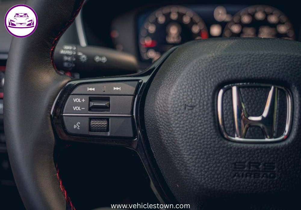 Honda Civic Si sporty red sedan parked, showcasing aggressive front grille and alloy wheels.