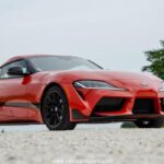 A sleek, red 2025 Toyota GR Supra 3.0 sits parked, highlighting its aggressive styling and ready-to-drive presence.