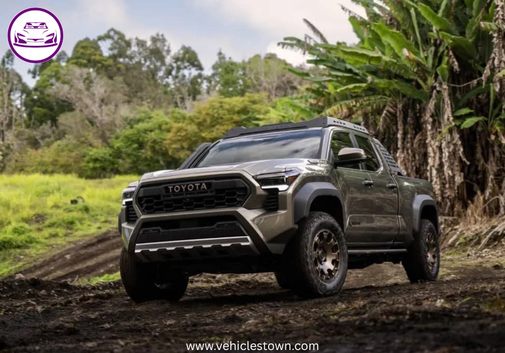 Front angle of the Toyota Tacoma i-FORCE MAX highlighting its bold grille and hybrid badging.