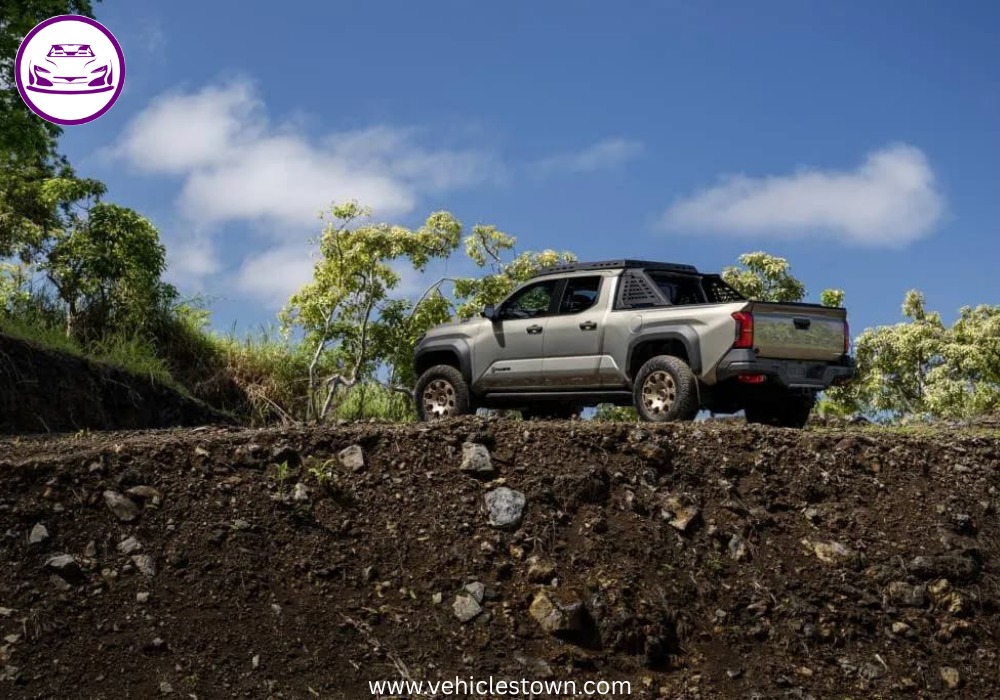 Front angle of the Toyota Tacoma i-FORCE MAX highlighting its bold grille and hybrid badging.