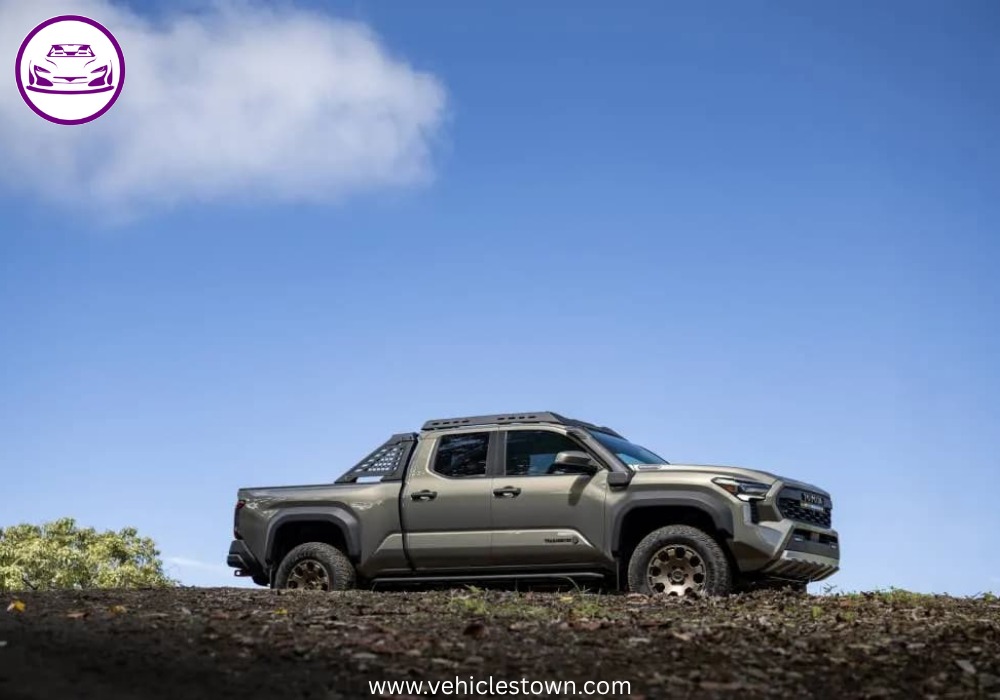 Front angle of the Toyota Tacoma i-FORCE MAX highlighting its bold grille and hybrid badging.