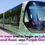 A modern electric tram moving on Lahore's Canal Road during a test run